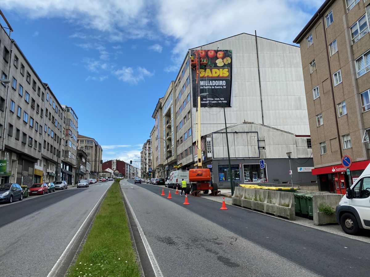 Lona publicitaria de gran formato instalada en la fachada de un edificio en Milladoiro