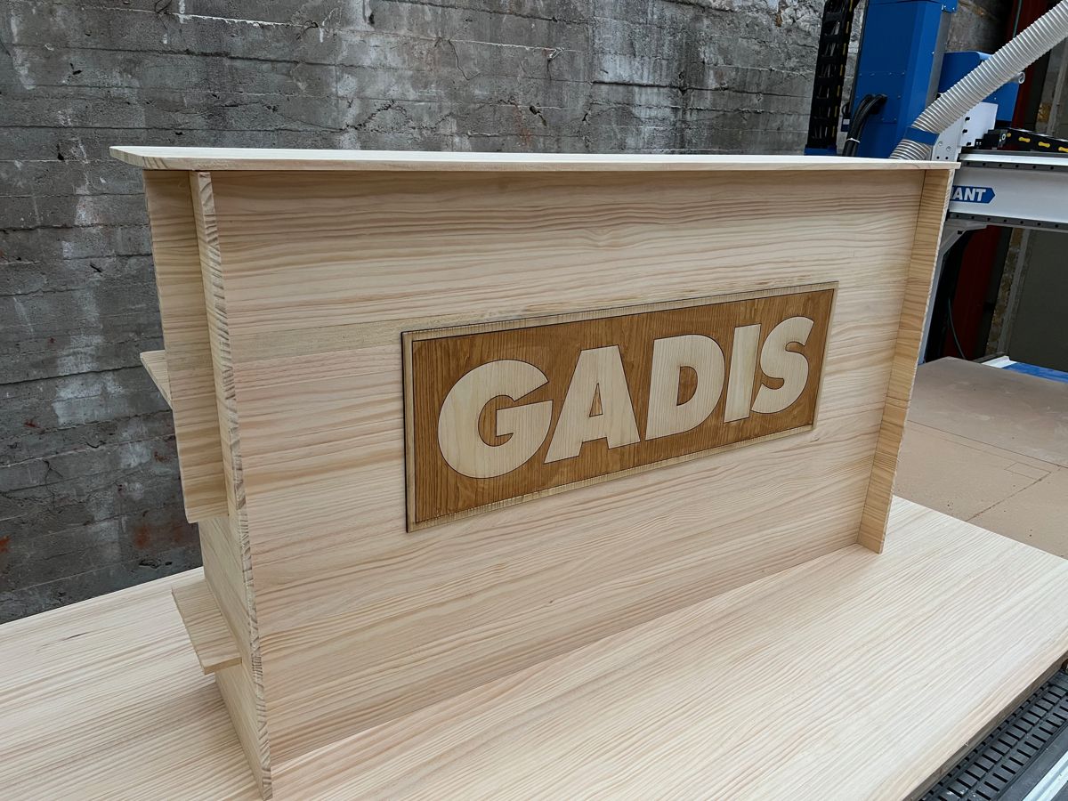 Mostrador de madera a medida con logotipo fabricado en el taller